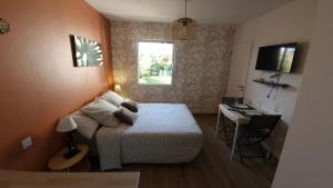 a small bedroom with a bed and a desk at Studio La passagère in Plouvorn