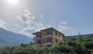 a building on the side of a hill with the sun at Guesthouse Thea in Naousa