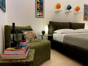 a bedroom with a couch and a bottle of wine on a table at Domus Settecento in Putignano