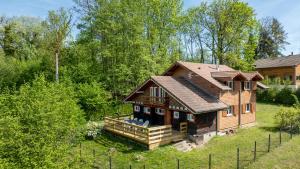 a large wooden house in the middle of a yard at Le Chalet in Anthy