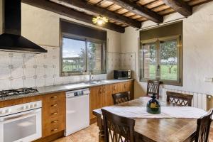 a kitchen with a wooden table and a dining room at Mas Pareta - La Morera in Fonolleras