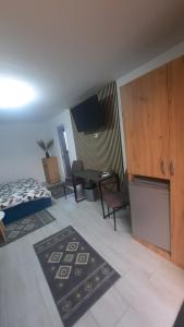 a room with a bed and a table and chairs at Casa Bon Relax , Rooms&Apartaments in Tuzla