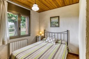 a bedroom with a bed and two windows at Mas Pareta - La Morera in Fonolleras +27 photos