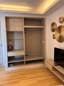 a living room with a tv and some shelves at Coconut Studio Aonang in Ao Nang Beach