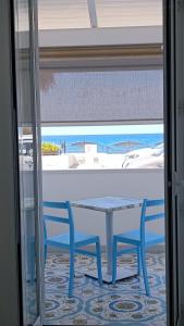 a table and chairs in a room with a view of the ocean at B & Beach in Agropoli