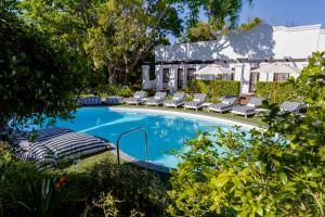 a swimming pool with lounge chairs and a house at The Claremont Boutique Hotel in Cape Town