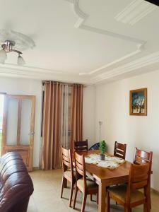 a dining room with a wooden table and chairs at HD Luxury Apparts in Yaoundé +11 photos
