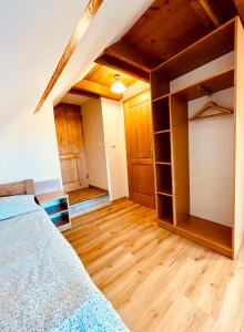 a bedroom with a bed and wooden floors at Ubytování u Chladů in Horská Kvilda