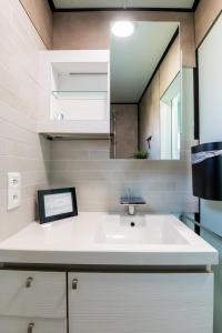 a bathroom with a sink and a mirror at Wonderful chalet in De Haan in De Haan +25 photos