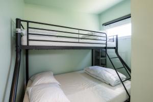 a bunk bed with two white pillows on it at Wonderful chalet in De Haan in De Haan