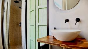 a bathroom with a white bowl on a wooden table next to a door at META Affittacamere in Càbras