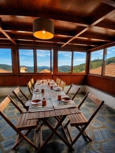 a long table with chairs in a room with windows at Casa da Comareira in Góis