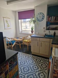 a kitchen and living room with a clock on the wall at Brighton West Pier flat in Brighton & Hove