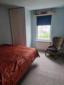 a bedroom with a bed and a chair and a window at Brighton West Pier flat in Brighton & Hove