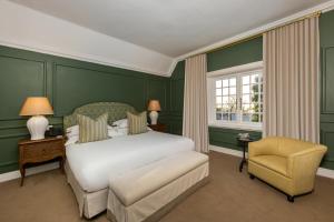 a bedroom with a white bed and a chair at The Claremont Boutique Hotel in Cape Town +23 photos
