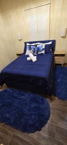 a blue bed with two pillows and two blue rugs at Cozy Hub -B in Philipsburg