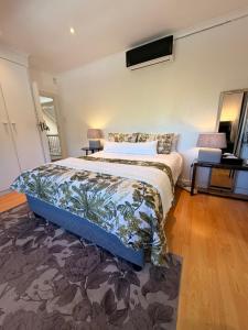 a bedroom with a king sized bed and a rug at Almond Cottage Bed & Breakfast in Somerset West +70 photos