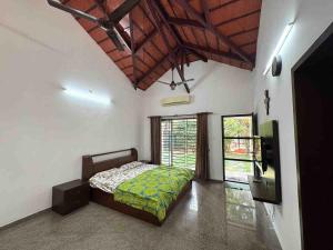a bedroom with a bed and a large window at Rego Farms in Mangalore