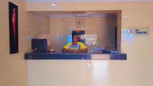 a person is standing behind a counter in a restaurant at Daikon Garden Hotel in Ekwulobia