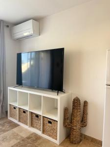 a flat screen tv sitting on top of a white entertainment center at LE TERRACOTTA COTE D'AZUR - Proche PLAGE - Terrasse & Confort - CLIM - Parking et Wifi Gratuit- OFFRE SPECIALE in Fréjus
