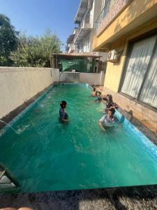 a group of people swimming in a swimming pool at Jannat Villa by Book Ur Stay in Lonavala