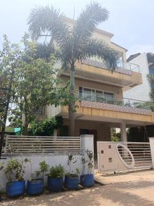 a house with a palm tree in front of it at Jannat Villa by Book Ur Stay in Lonavala