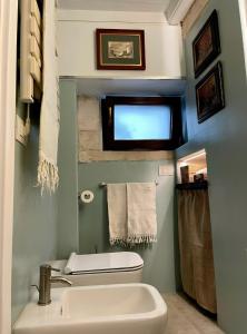 a bathroom with a white toilet and a sink at Domus Settecento in Putignano +19 photos
