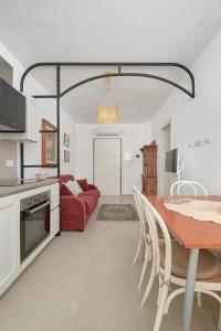 a living room with a table and a red couch at Casa vacanze vento di mare in Alghero