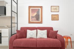 a red couch with two pillows in a living room at Casa vacanze vento di mare in Alghero