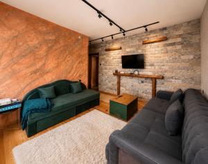 a living room with a couch and a tv at Krisiya's Apartment in Bansko