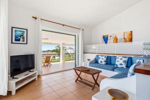 a living room with a blue couch and a tv at Villa Ana by Escape Home in Santo Tomás
