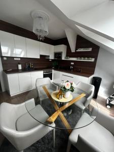 a kitchen with a glass table and white chairs at The Manor in Pilsen