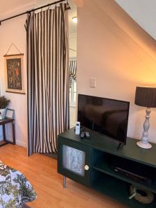 a living room with a flat screen tv on a table at Almond Cottage Bed & Breakfast in Somerset West