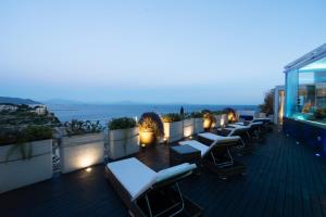 eine Reihe von Liegestühlen auf einem Balkon bei Nacht in der Unterkunft Aquaboutique Wellness&Spa in Vietri