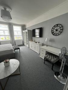 a living room with a bed and a clock on the wall at The Manor in Pilsen