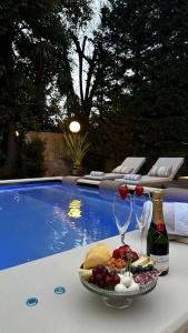 a plate of food and wine on a table next to a pool at Villa Palmira Kinderfreies Hotel in Cannobio