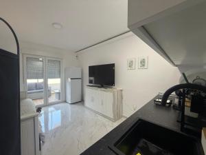 a living room with a flat screen tv and a refrigerator at Estudio Cuidad Quesada in Rojales