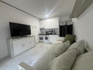 a living room with a couch and a flat screen tv at Estudio Cuidad Quesada in Rojales