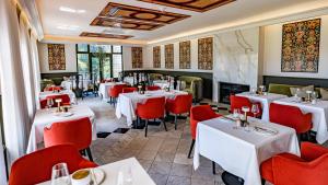 a restaurant with white tables and red chairs at The Claremont Boutique Hotel in Cape Town