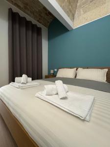 a bedroom with a large bed with towels on it at Antico castello BeB in Altamura