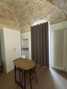 a room with a table and a window with a curtain at Antico castello BeB in Altamura