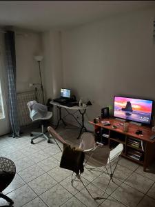 a living room with a tv and a table and chairs at Chambre confortable in Saint-Maur-des-Fossés