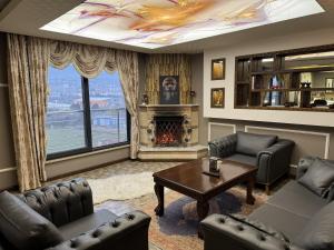 a living room with couches and a table and a fireplace at Grand Ali'n Tokat in Tokat