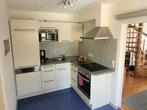 a kitchen with white cabinets and a stove top oven at Ferienwohnung Ipser in Vogtsburg