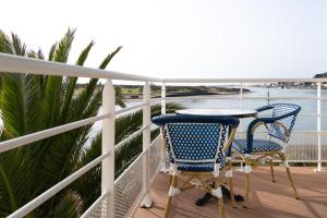 a table and chairs on a balcony with the ocean at Hôtel La Marine - Restaurant Marnage in Barneville-Carteret