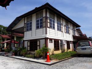 ein Haus mit einem davor geparkt in der Unterkunft Teratak Opah Kamunting in Taiping