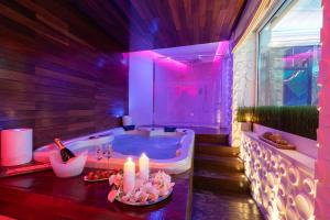 ein Badezimmer mit Badewanne, Kerzen und einer Flasche Wein in der Unterkunft Aquaboutique Wellness&Spa in Vietri