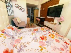 a bedroom with a bed with a floral bedspread at Arc tower- Sweet Stay Cebu in Cebu City +6 photos
