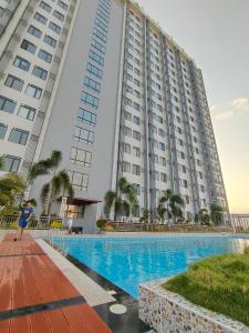 a large building with a swimming pool in front of it at Arc tower- Sweet Stay Cebu in Cebu City