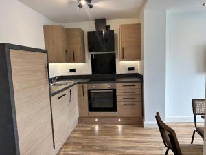 a kitchen with wooden cabinets and a black refrigerator at Roundhay Residences in Moortown +3 photos